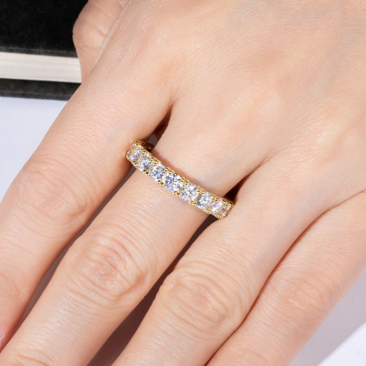 The Ora Band lifestyle — 3.5mm moissanite eternity band yellow gold worn on finger — Aurora Moissanite