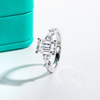 The Vale Ring worn — 3ct emerald 0.3ct pear moissanite two-stone, 18K gold — Aurora Moissanite