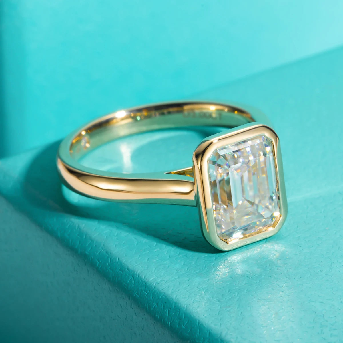 Emerald cut moissanite 3ct D color VVS1, yellow gold bezel setting detail — Aurora Moissanite