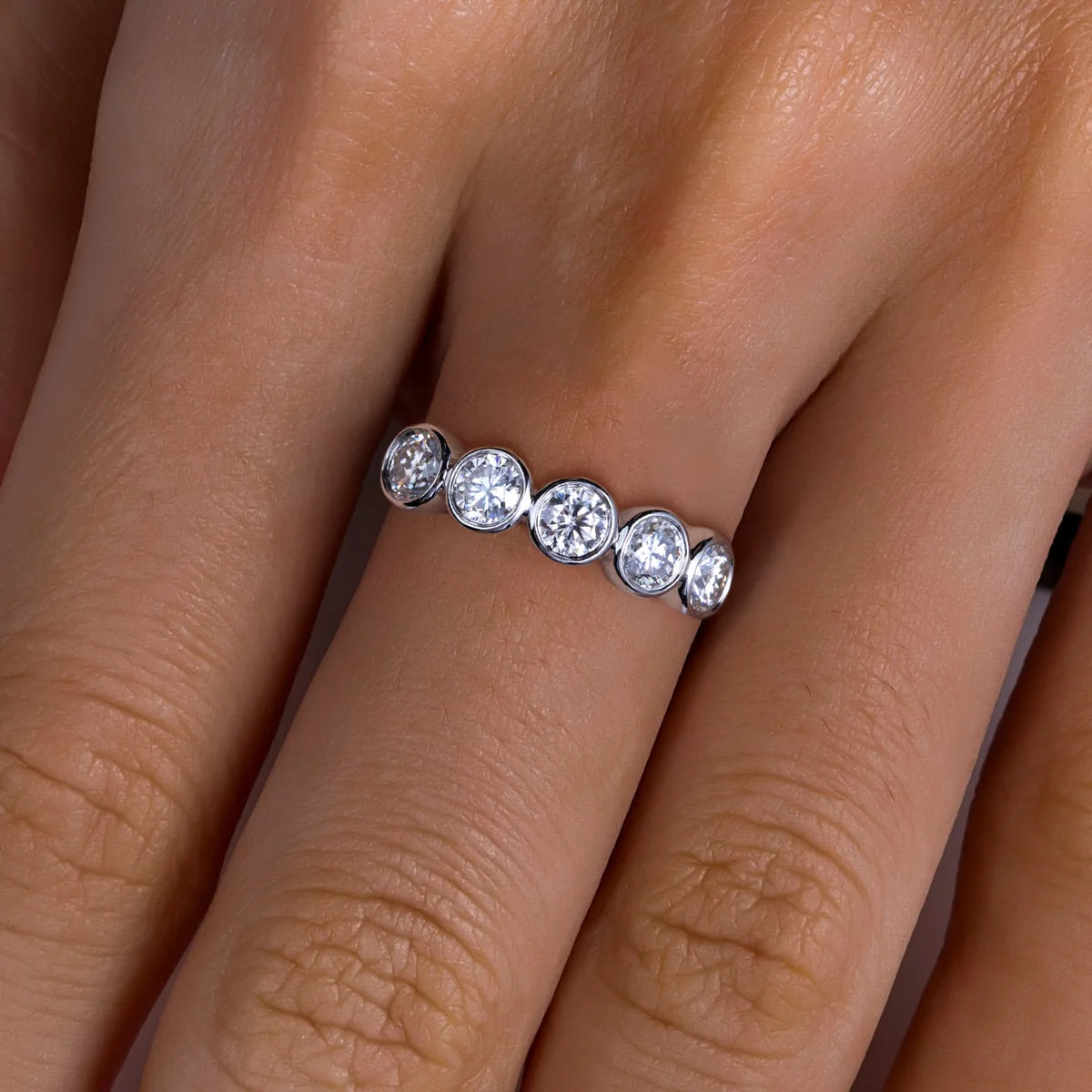 The Arch Band lifestyle — moissanite bezel half eternity ring worn on finger — Aurora Moissanite